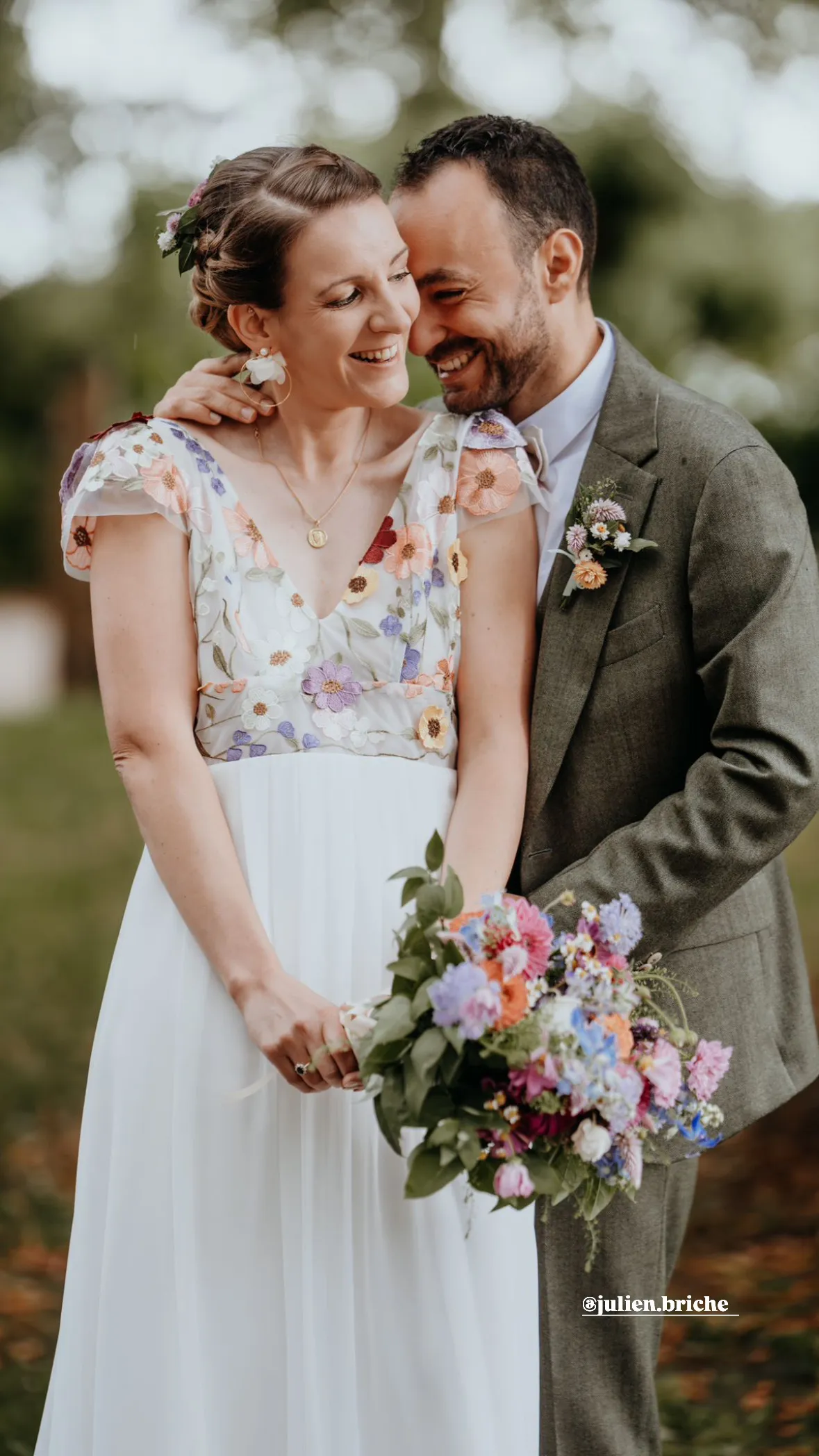 Mariés souriants avec bouquet champêtre coloré