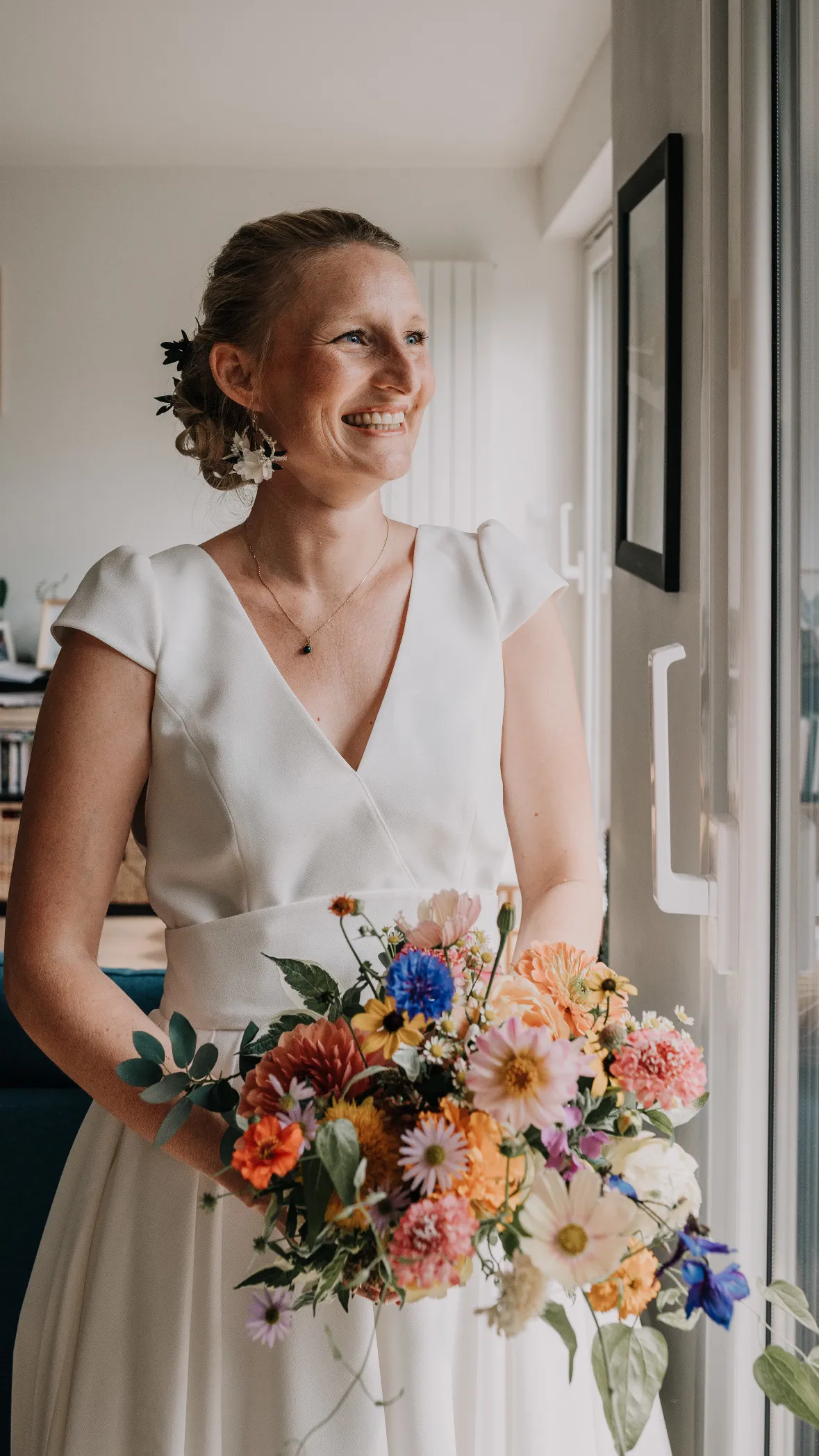 Mariée souriante avec bouquet champêtre coloré