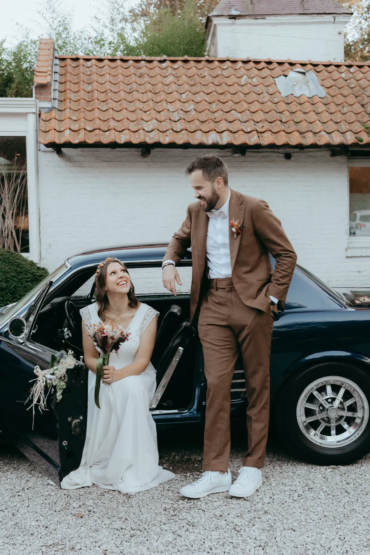 Mariés complices devant une voiture vintage